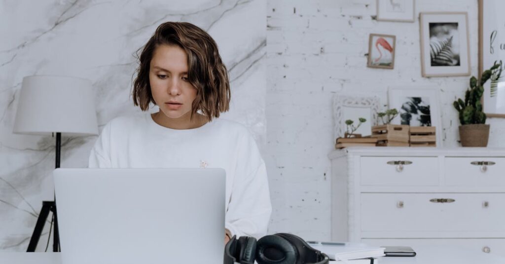 A woman focuses on her laptop in a modern home office setting, exemplifying remote work.
